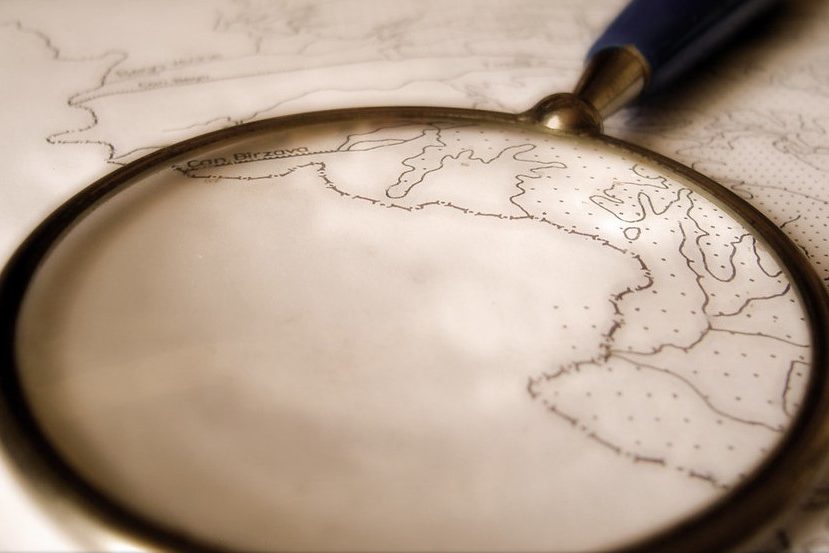 Image of a magnifying glass magnifying a portion of a map