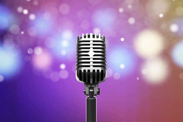 Microphone against multicoloured lights background