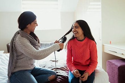 Young woman brushing girls hair