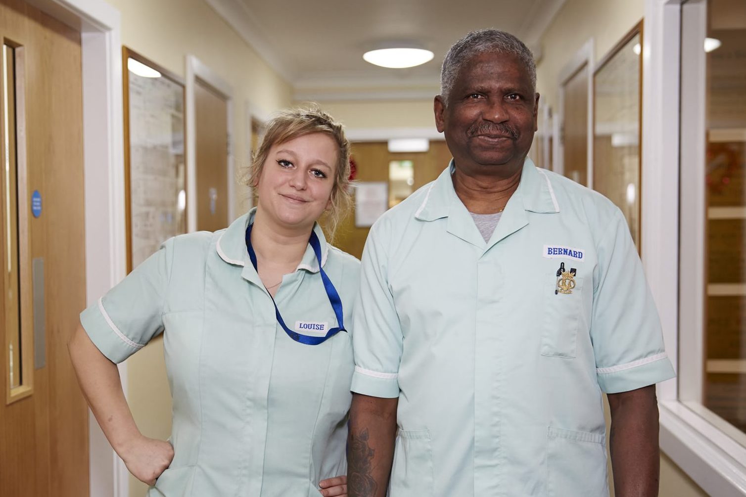 Two care workers in a care home corridor