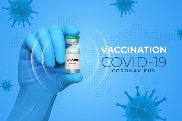COVID-19 vaccine vial being held in a gloved hand