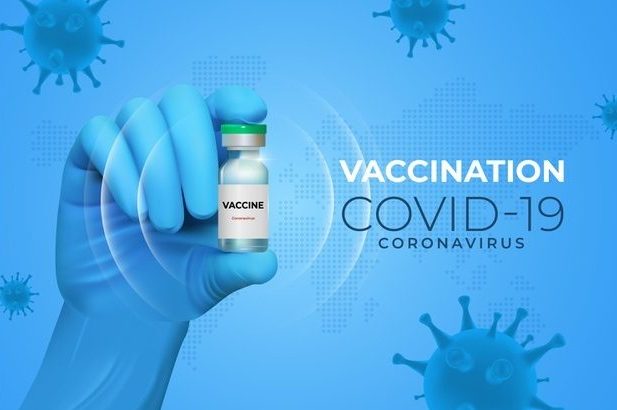 COVID-19 vaccine vial being held in a gloved hand