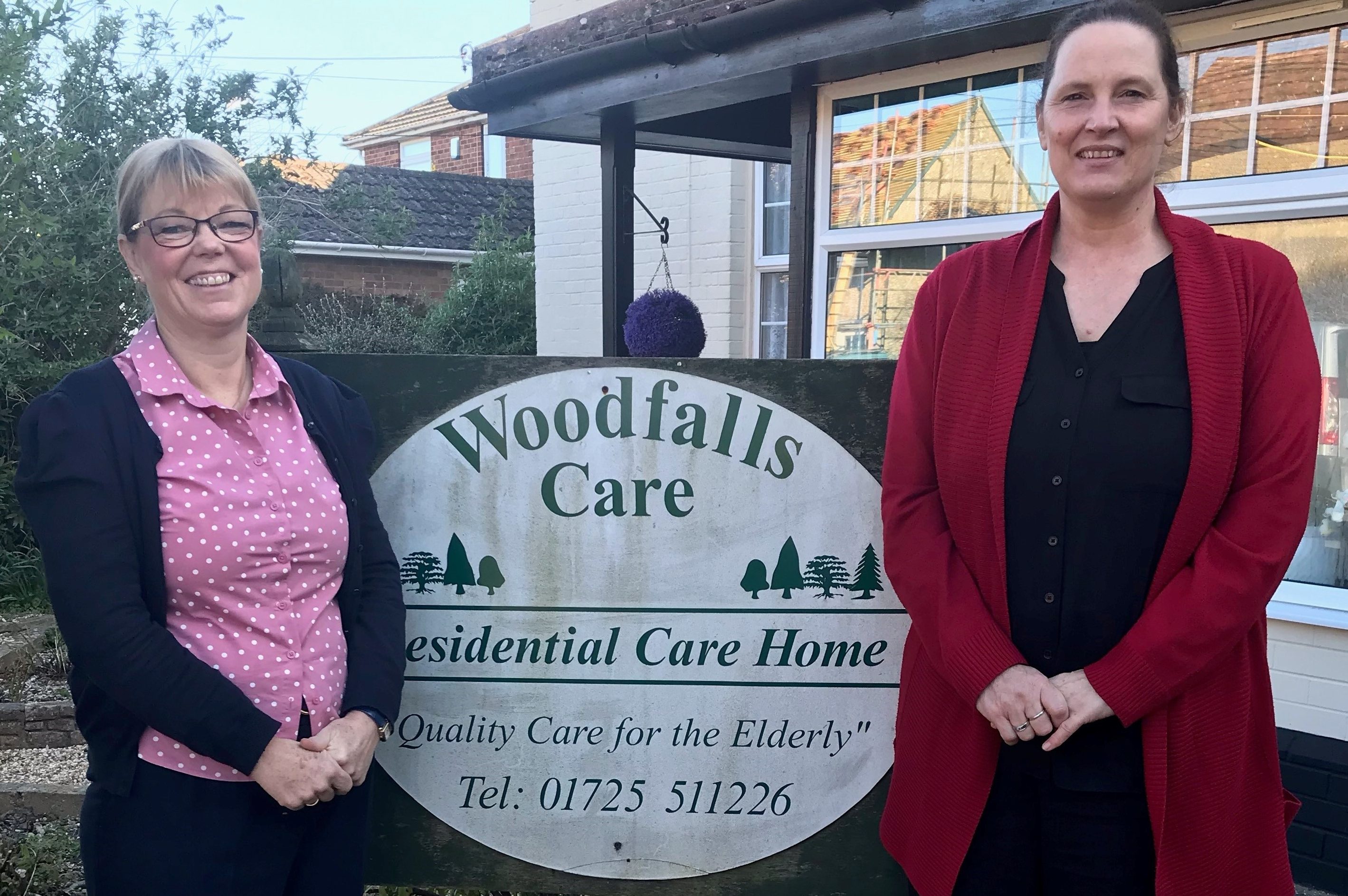 Alison and Pascalle standing beside the care home sign.