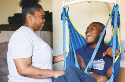 Care worker working with physically disabled young man