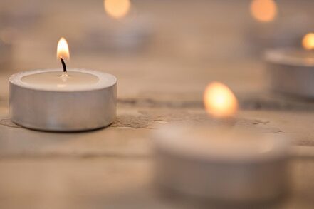 Candles burning on wooden plank