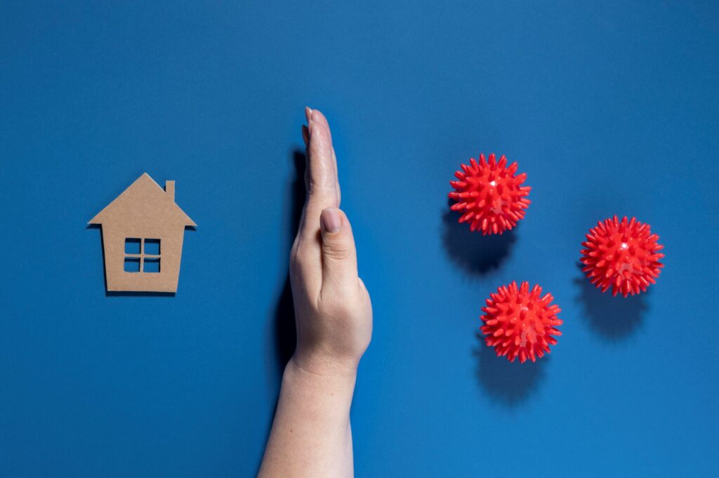 Hand creating barrier between house and germs
