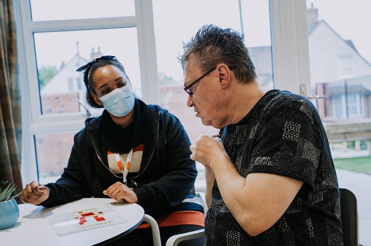 Care colleague and resident playing tabletop game