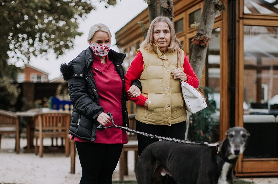 Care worker and older woman walking the dog