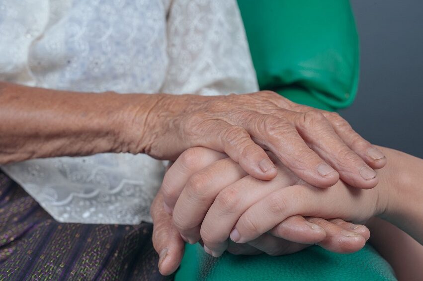 young-woman-holding-elderly-woman-s-hand.