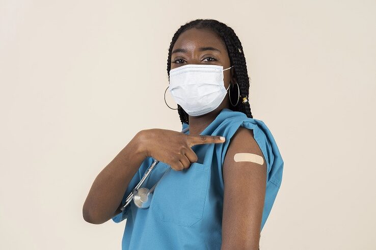 female-doctor-showing-arm-with-sticker-after-getting-vaccine