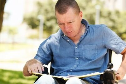 Man in wheelchair reading book