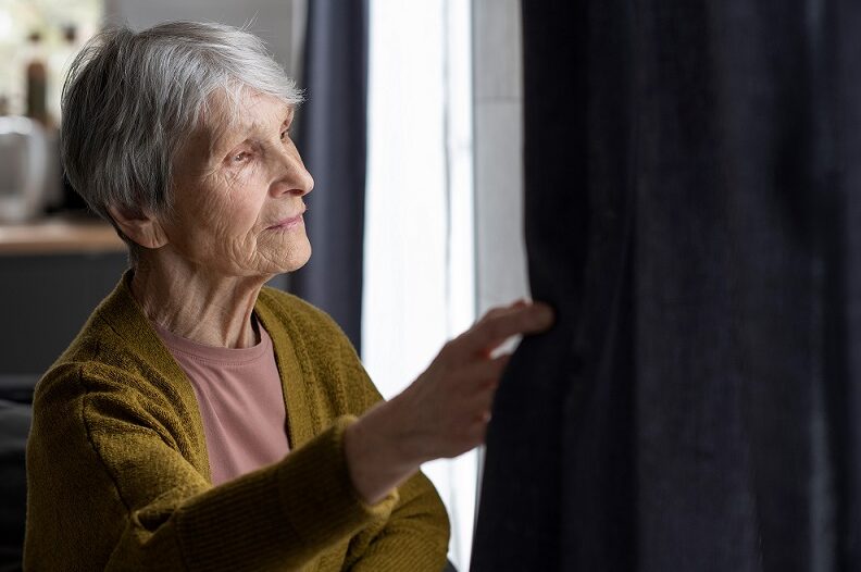 Older woman looking out of a window
