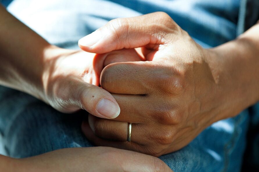 Care colleague holding resident's hand