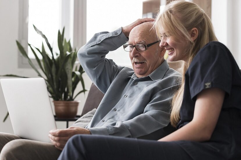 old-man-video-calling-family-from-nursing-home-with-care nurse