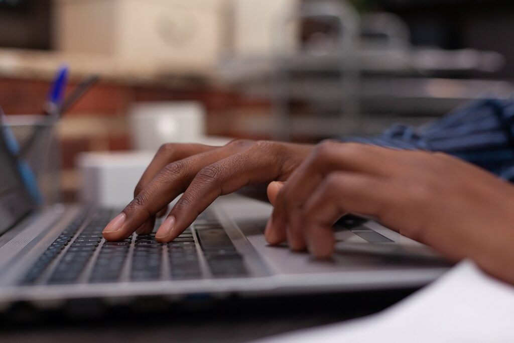 Man's hands typing at laptop