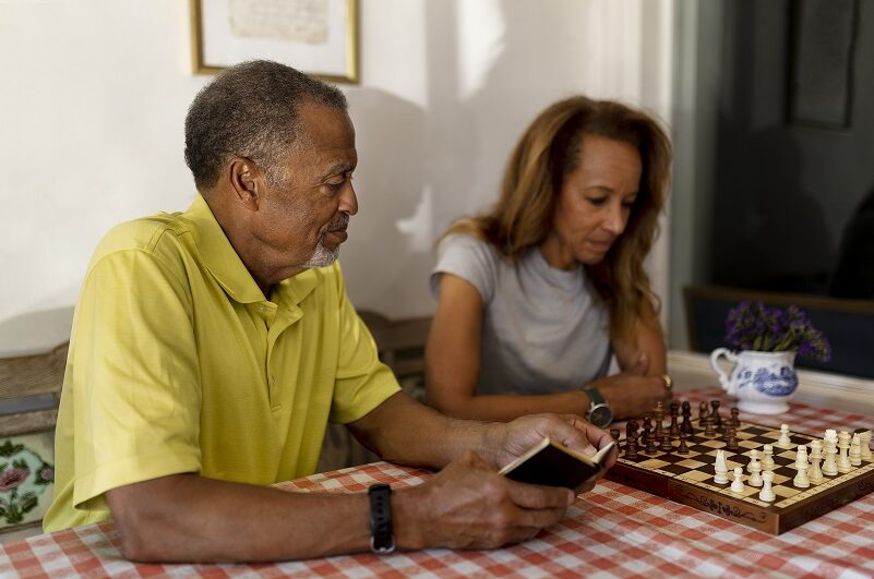 Elderly man and daughter playinc chess