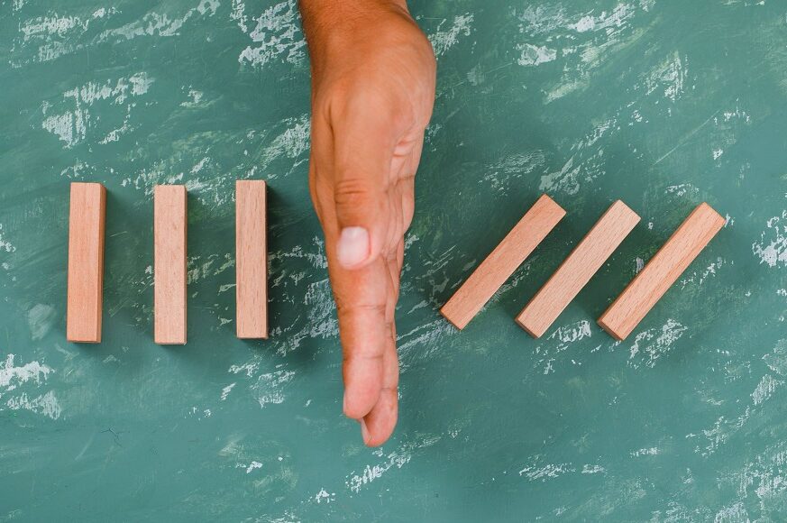 hand-as-barrier-dividing-wooden-blocks