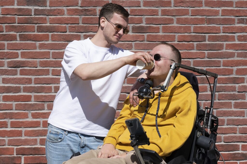 Man helping disabled relative to drink