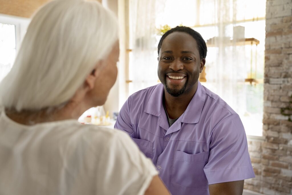 Male social care nurse with older resident