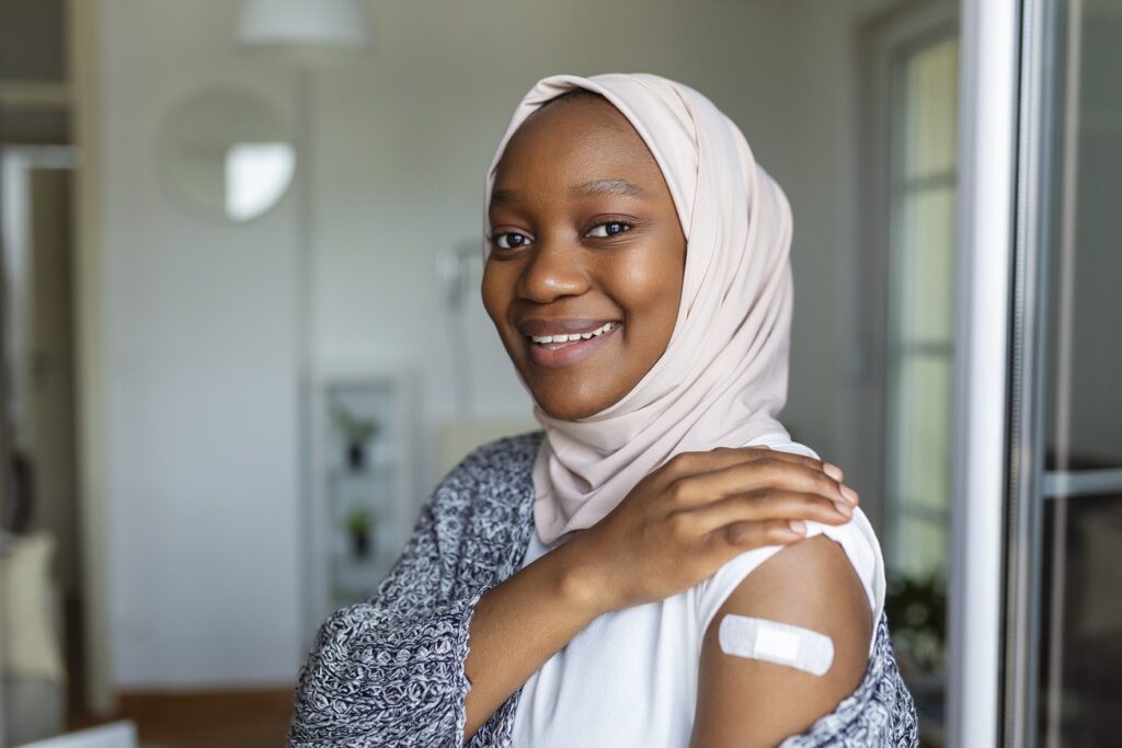 Woman showing her vaccination plaster